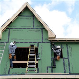 Construction crew members work on new houses near Larimer Avenue and Meadow Street.