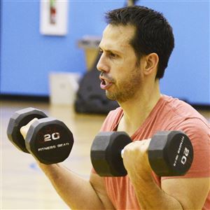 Kevin Caridad, of Seven Fields, works out with weights during a Tabata class.