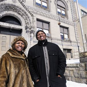 Carolyn Davis and her son, Charlie, the executive director and development director, respectively, of the Schenley Height Community Development Program, stand in front of the Madison School in the Upper Hill.