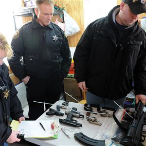 Detective Barb Sparrow, left, and Deputies Mark Lewis, center, and Tom Ninehouser, right, process guns surrendered during the 