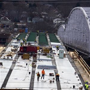 Construction crews work on the new Hulton Bridge in Marsh. The bridge, which spans Oakmont and Harmar, will open to traffic on Oct. 20. The existing bridge, pictured to the right, is closed to traffic through Oct. 19 as crews work to rebuild parts of Hulton Road in preparation for the opening of the new bridge.
