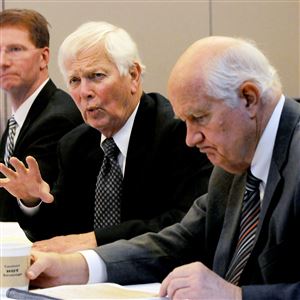 Arbitrator Bill Miller, middle, makes note of an objection during the public arbitration talks on the upcoming police contract. Arbitrators A. Bryan Campbell, left and Rich Miller listen.