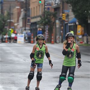 Ashley Smith and Sophia Swinderski roller skating down Butler Street in Lawrenceville on Sunday during OpenStreetsPGH, a free public event that make streets pedestrian-only.