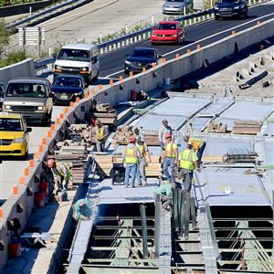 Workers lay down new decking on the Parkway West bridges over Chartiers Creek in Carnegie last year. 