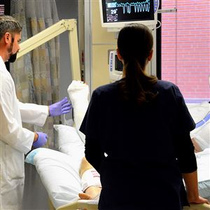 Ariel Aballay, medical director of the West Penn Hospital burn unit, examines a burn victim Wednesday at the hospital. Gov. Tom Wolf vetoed supplemental funding for the hospital as the state budget impasse continues.