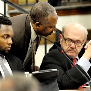 Thomas Sumpter, center, speaks Wednesday with attorney Ira Weiss, right, as Ronald Joseph listens to the agenda at a Pittsburgh school board meeting in Oakland.