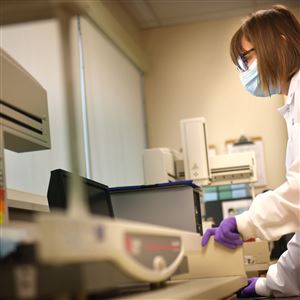 A DNA analyst sets up a robot that handles and transfers samples in the forensic laboratory at the Allegheny County Medical Examiner's Office.
