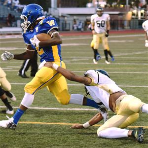 Richard Stone (1) from Brashear tries to stop Genaro Coleman (2) from Westinghouse after Coleman snatched up Brashear’s fumbled ball in the end zone at George Cupples Stadium in South Side on Thursday.