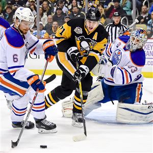 Evgeni Malkin battles for a loose puck in front of Oilers goalie Cam Talbot in the first period Tuesday at PPG Paints Arena.