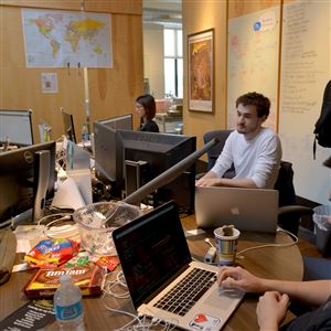 Tyler Kaelin, Xin Liang, Alex Klimerman and Kinardi Isnata work at their terminals at the TrademarkVision office in Uptown in May.
