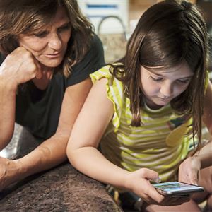 Donna Walker and her 10-year-old granddaughter Izzy Walker look through photos of Izzy and her mom on Wednesday, May 23, 2018, in their South Park Township kitchen. Izzy calls her grandmother 