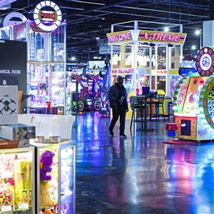 Lights from rows of games and prizes reflect off the floor at Scene75 Entertainment Center in Edgewood Towne Centre as employee Latete DeWese of West Mifflin makes his way across the arcade during a 