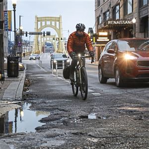 Tom Borner of Bridgeville bikes through Downtown on his way to Oakland on Wednesday, Nov. 28, 2018, Downtown. Mr. Borner, an avid cyclist, believes bike lanes should be added to the West End Bridge. 