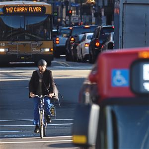 A cyclist makes his way using the bus lane along Smithfield Street as traffic heads inbound during the morning commute in Downtown in September.