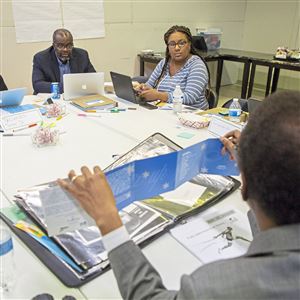 Russell Bynum of the North Side, bottom, gives a marketing and advertising presentation to Entrepreneurship Academy students. From left, Tacumba Turner of Sheraden, John Wallace, professor social work at University of Pittsburgh, pastor of Bible Center Church and program director, Lelia Broughton of Penn Hills, and Tra' Ward of Penn Hills.