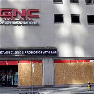A construction crew has boarded up the GNC Building, Downtown, on Sixth Avenue on Tuesday, Nov. 3, 2020.