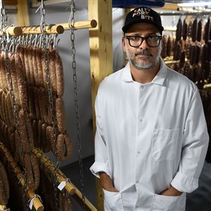 Justin Severino stands among varieties of drying salami in his Lawrenceville facility.