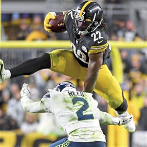 Najee Harris of the Pittsburgh Steelers jumps over defender D.J. Reed