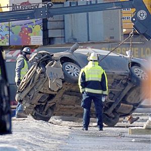 Crews work to unleash a car from a crane that was retrieved from the collapsed Fern Hollow Bridge, Monday, Jan. 31, 2022, near Frick Park.
