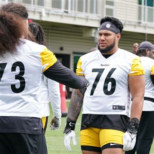 El guardia de los Steelers, Isaac Seumalo, da consejos al tackle novato de primera ronda Troy Fautanu durante la práctica de OTA en el UPMC Rooney Sports Complex en el lado sur el jueves 23 de mayo de 2024.