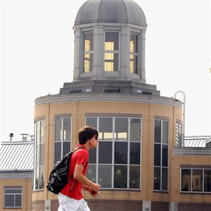 A student walks to class, with the Edward Nicholason Center in the background at Robert Morris University.