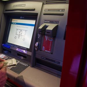 A customer withdraws money from an automatic teller machine inside a Bank of America branch in New York on Jan. 13, 2018.