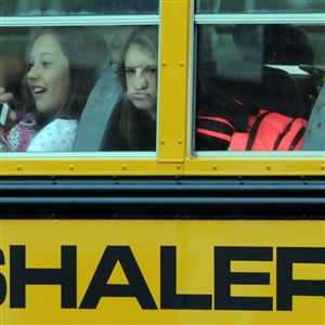 Students watch as their school bus nears the entrance to Shaler Area Middle School along Mount Royal Boulevard for a delayed first day of school Friday. Earlier in the week, the school district reached an agreement with striking teachers on health care contributions and workload. 