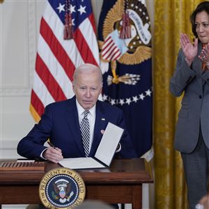 President Joe Biden signs an executive order on artificial intelligence in the East Room of the White House, Monday, Oct. 30, 2023, in Washington. Vice President Kamala Harris applauds at right. 
