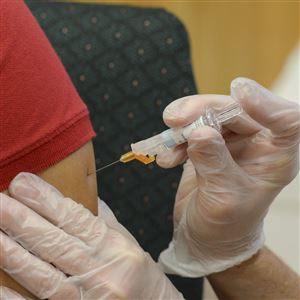 A woman receives a flu vaccine shot 