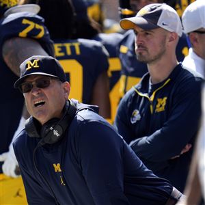 Michigan head coach Jim Harbaugh, front left, watches against Rutgers as analytics assistant Connor Stalions, right, looks on during an NCAA college football game in Ann Arbor, Mich., Sept. 23, 2023. Stalions was suspended by the university last week and is at the center of a sign-stealing scheme that is being investigated by the NCAA.