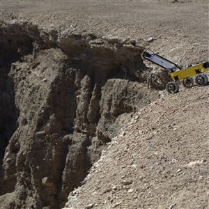 Jordan Ford, a recent Carnegie Mellon University graduate student, peers over the edge of a pit in Utah with a robot designed to see if similar pits on the moon could be habitable for astronauts. Courtesy Jordan Ford. A robot designed to see if lunar pits could be habitable gets some practice on a pit in Utah. NASA has not yet committed funding to sending the CMU project to the moon. 