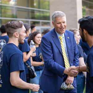 University of Pittsburgh’s 18th chancellor, Patrick Gallagher, shakes hands with University of Pittsburgh students. 