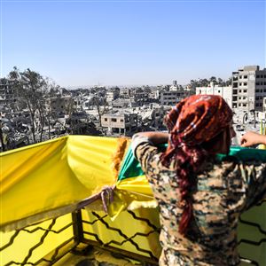 A female fighter of the Syrian Democratic Forces looks on during celebrations at the iconic Al-Naim square in Raqqa on October 19, 2017, after retaking the city from Islamic State fighters.