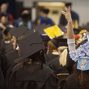 A graduate waves to people in the audience at the commencement ceremony at Clarion University on May 13, 2017, in Clarion.