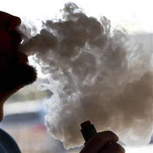 In this January 2019 file photo, a man exhales a puff of smoke from a vape pipe at a shop in Richmond, Va. In Pennsylvania, the Dept. of Health confirmed the first death related to vaping on Friday, October 4, 2019.  