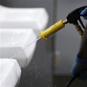 In this March 19 file photo, a public school employee sanitizes a sink in a bathroom at a U.S. high school. Jobs with state and city governments are usually a source of stability in the U.S. economy, but the financial devastation wrought by the coronavirus pandemic has forced cuts that will reduce public services, from schools to trash pickup.