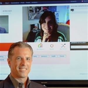 Mike Elchik, president and CEO of WeSpeke — an online community for people to teach, learn and practice languages — at his office in Crafton. Projected on the screen are Dafyd Jones, left, WeSpeke Web developer, and Marisol Garcia in Madrid.
