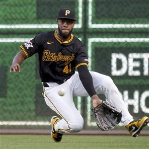 Pittsburgh Pirates right fielder Bryan De La Cruz reaches but cannot catch a single hit by Cincinnati Reds' Amed Rosario during the fifth inning of a baseball game Thursday, Aug. 22, 2024, in Pittsburgh. 