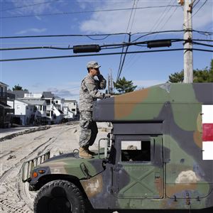 Kevin Cassano of the New Jersey National Guard stands atop a Humvee to gain better cellphone reception during the guard's patrol of Long Beach Island, N.J., Oct. 31, 2012. Top executives with Ibis Tek, a Butler County company that had a contract with the U.S. Army, have pleaded guilty in federal court in Pittsburgh to defrauding the government of $6 million by falsely inflating the costs to make emergency window escape kits for Humvees. 