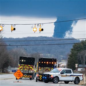 South Beaver police block Route 51 as smoke billows from the train derailment site a few miles away in East Palestine, Ohio, on Monday, Feb. 6, 2023. 