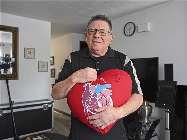 Heart bypass patient Mark Klein,72, holds the heart pillow he used during his recovery from heart surgery at his home in Plum.