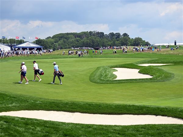 Scottie Scheffler and his caddie leave the 8th hole on the second practice day at the U.S. Open at Oakmont Country Club on Tuesday, June 10, 2025.