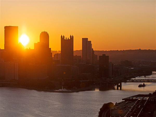 The sun rises behind the Downtown Pittsburgh skyline on Oct. 10, 2019.