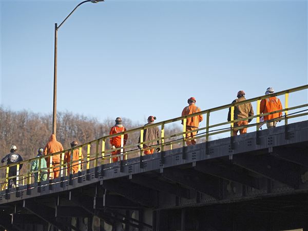 U.S. Steel workers cross a bridge walking toward the Clairton Mill Works after a rally in support of the company’s proposed $15 billion sale to Nippon Steel, outside of the Mill Works in Clairton on Dec. 12, 2024. The deal remains in limbo as a national security review was supposed to wrap up Wednesday. 