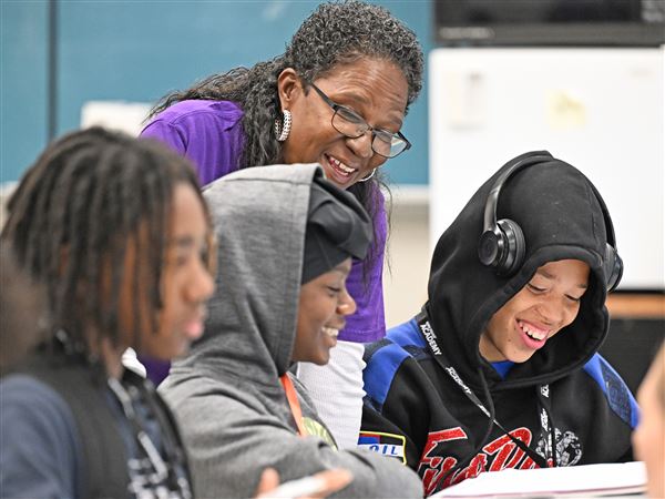 AmeriCorps member Terri Wright Jones, center, helps Tobias Igles, left, and Mike Hall- Cunningham with school work at Pittsburgh Westinghouse 6-12 through Homewood Children's Village on Thursday, May 22, 2025. Homewood Children's Village is one of several programs in the Pittsburgh area impacted by the AmeriCorps cuts. The organization uses AmeriCorps members to go into schools including Pittsburgh Faison, Lincoln and Westinghouse as well as the Urban Academy Charter School to help improve students' academic engagement and performance. The organization was able to obtain a grant to continue working this school year following the cuts.