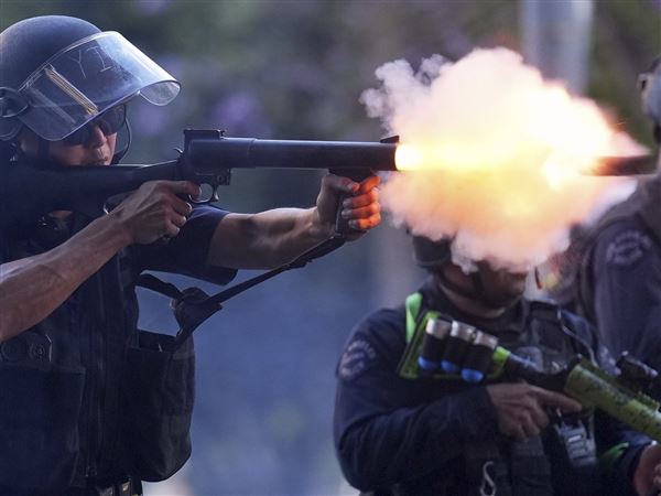 A police officer fires a soft round near the metropolitan detention center of downtown Los Angeles, Sunday, June 8, 2025, following an immigration raid protest.
