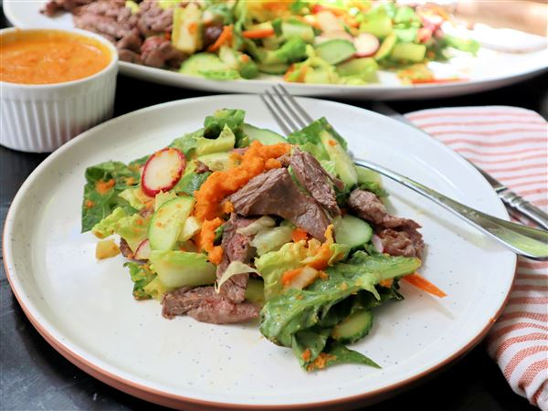 Quick-grilled skirt steak tops a spring salad of romaine, radish and cucumber dressed in a carrot-ginger vinaigrette.