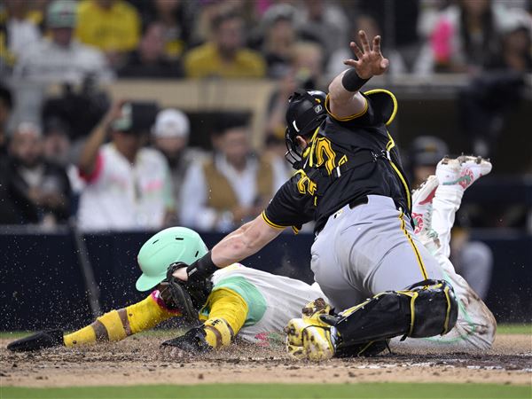 The Padres' Luis Arraez slides home to score a run ahead of the tag by Pirates catcher Henry Davis during the sixth inning at Petco Park on May 30, 2025, in San Diego.