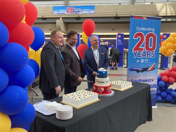 Southwest Airlines Regional Manager of Airport Affairs Mike Gillock (center), joined by Allegheny County Airport Authority's Director of Air Service Development Joe Rotterdam (left) and its Chief Government & Corporate Affairs Officer Vince Gastgeb (right), cuts into a cake commemorating the airline's 20 years of service at Pittsburgh International Airport in the landside terminal on May 20, 2025. 