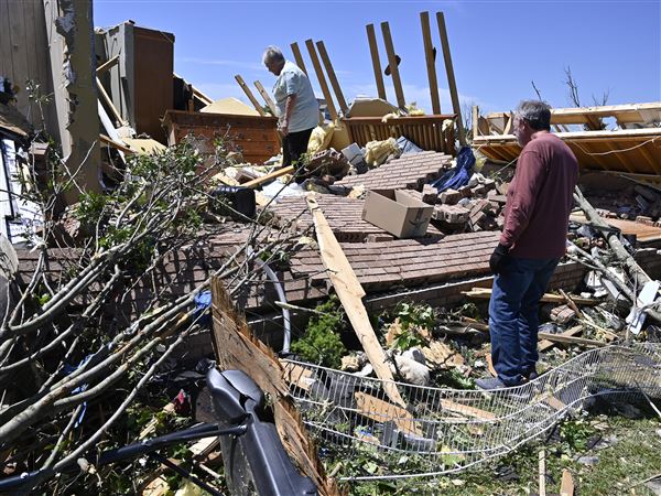 Doris Hensley, center, and Don Allen look over the remains of her home following severe weather in London, Ky., Saturday, May 17, 2025.